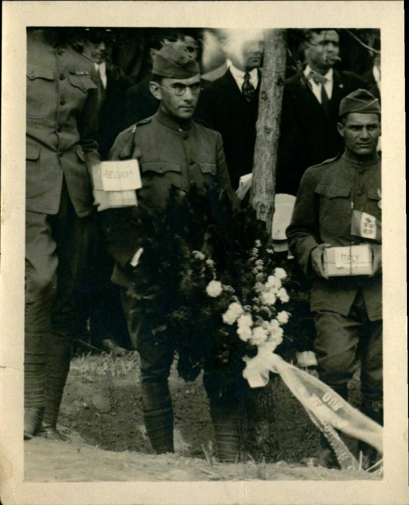 Photograph of a service member holding parcels of soil at the planting ceremony
